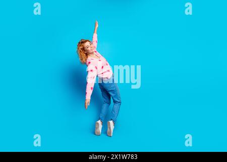 Foto in voller Länge von attraktiven jungen Frauen-Zehenspitzen, die zurück fallen gekleidete stilvolle rosa Kleidung isoliert auf blauem Hintergrund Stockfoto