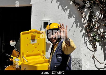 Solabrena, Ein lächelnder Postbote in gelber Uniform, grüßt freundlich während der Zustellung der Post, Andalusien, Spanien Stockfoto