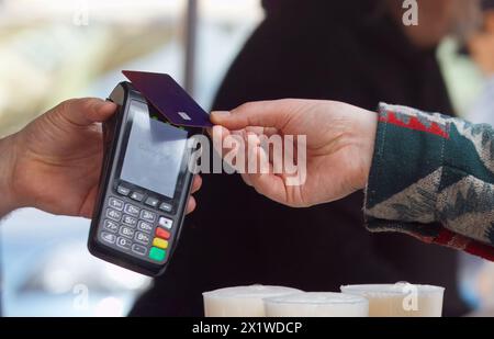 Mitte der Leiche eines Mannes, der eine Online-Kartenzahlung an einem Terminal auf einem Bauernmarkt im Freien in Naplavka in Prag, Tschechien, durchführt Stockfoto