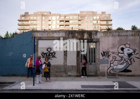 Menschen, die am 7. Mai 2022 an einer Bushaltestelle vor einer Mauer mit einem Graffiti-Gemälde einer Maus in Porto im Norden Portugals warteten. Personnes Attendant A Stockfoto