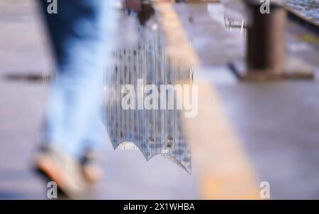 Hamburg, Deutschland. April 2024. Die Elbphilharmonie spiegelt sich in einer Pfütze an den Landungsbrücken im Hafen wider. Quelle: Marcus Brandt/dpa/Alamy Live News Stockfoto