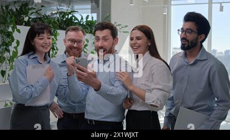 Glücklich begeistert überrascht Geschäftsteam Geschäftsleute Geschäftsfrauen feiern Sieg im Büro multirassische Gewinner Mitarbeiter Investoren Stockfoto