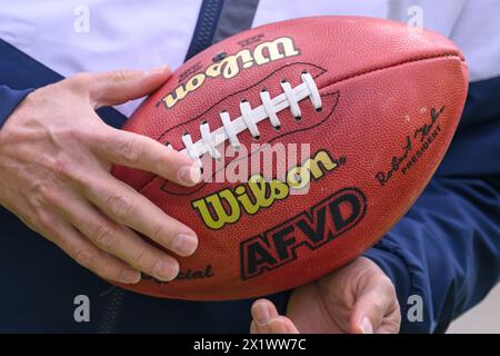 Dresden, Deutschland. April 2024. Ein Teilnehmer einer Presseveranstaltung hält auf der Baustelle des Heinz-Steyer-Stadions im Ostragehege einen American Football in den Händen. Nach gut zwei Jahren Bauzeit befindet sich nun die Sanierung und Erweiterung der Sportanlage auf der Heimgerade. Das Stadion soll am 30. August 2024 eröffnet werden. Robert Michael/dpa/Alamy Live News Stockfoto