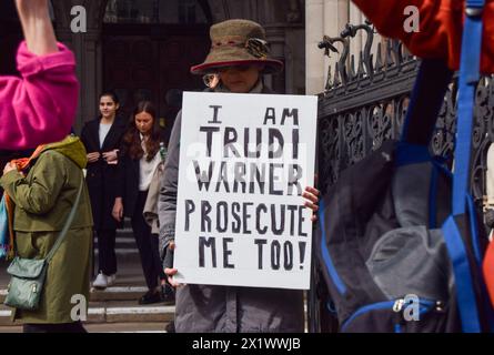 London, Großbritannien. April 2024. Anhänger stehen mit Plakaten, während die Klimaaktivistin Trudi Warner den Obersten Gerichtshof nach einer Entscheidung verlässt. was sich nun verzögert hat, ob sie wegen Missachtung des Gerichts vor einer vollständigen Verhandlung stehen wird, weil sie ein Plakat gehalten hat, auf dem steht: "Geschworene, Sie haben ein absolutes Recht, eine Angeklagte nach Ihrem Gewissen außerhalb des inneren Londoner Crown Court in einem separaten Fall freizusprechen. was ein Richter als „Versuch, die Geschworenen zu beeinflussen“ ansah. Quelle: Vuk Valcic/Alamy Live News Stockfoto