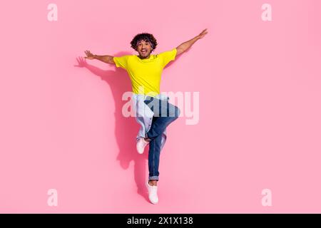 Foto des lustigen fröhlichen netten Mannes tragen stilvolle gelbe Kleidung Aise Hände Arme isoliert auf rosafarbenem Hintergrund Stockfoto