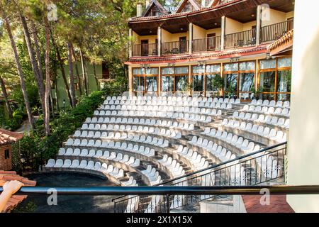 Open-Air-Amphitheater für Abendvorführungen in einem Hotel an der Küste, umgeben von üppiger Vegetation und hohen Kiefern Stockfoto