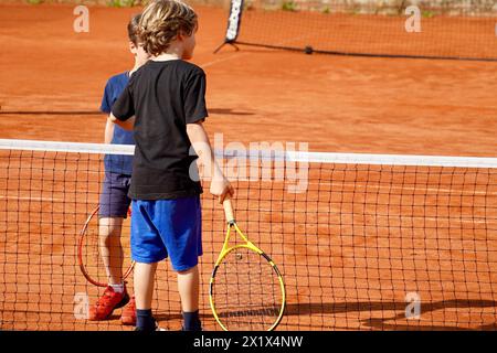 Die Gegner schütteln sich nach ihrem Tennisspiel die Hände, zeigen sportliche Fähigkeiten und Freundschaft Stockfoto