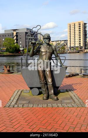 Lebensgroße Bronzestatue eines Kohlebergbauers - von der Grube zum Hafen - vom Künstler John Clinch, Britannia Quay. Cardiff Bay. Aufgenommen 2024 Stockfoto