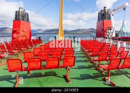 Rote Sitzplätze auf der Aussichtsplattform des Caledonian MacBrayne MV Argyle, mit der Isle of Bute im Hintergrund, Schottland, Großbritannien Stockfoto