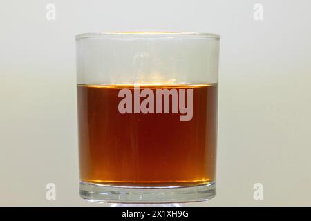 Brauner Zucker in einem Glas warmem Wasser gelöst Stockfoto