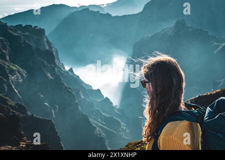 Beschreibung: Porträt einer Backpackerin, die in ein tiefes, wolkenbedecktes Tal blickt und den atemberaubenden Blick auf den vulkanischen mount genießt Stockfoto