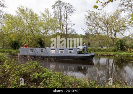 London, Großbritannien. April 2024. Zwei Personen auf einem Schmalboot fahren durch einen Abschnitt des Grand Union Canal in Harefield. Quelle: Mark Kerrison/Alamy Live News Stockfoto