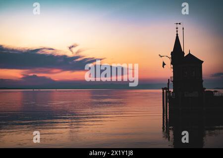 Beschreibung: Schöner Blick auf Sonnenaufgang von der Imperia-Statue zum Leuchtturm am Hafeneingang und am Bodensee in den frühen Morgenstunden. Steamer Harbour, Co Stockfoto