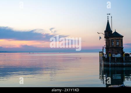 Beschreibung: Schöner Blick auf Sonnenaufgang von der Imperia-Statue zum Leuchtturm am Hafeneingang und am Bodensee in den frühen Morgenstunden. Steamer Harbour, Co Stockfoto