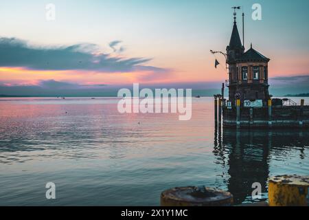 Beschreibung: Schöner Blick auf Sonnenaufgang von der Imperia-Statue zum Leuchtturm am Hafeneingang und am Bodensee in den frühen Morgenstunden. Steamer Harbour, Co Stockfoto