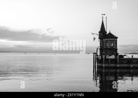 Beschreibung: Schöner Blick auf Sonnenaufgang von der Imperia-Statue zum Leuchtturm am Hafeneingang und am Bodensee in den frühen Morgenstunden. Steamer Harbour, Co Stockfoto