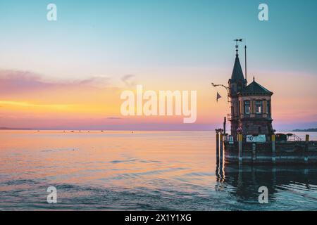 Beschreibung: Schöner Blick auf Sonnenaufgang von der Imperia-Statue zum Leuchtturm am Hafeneingang und am Bodensee in den frühen Morgenstunden. Steamer Harbour, Co Stockfoto