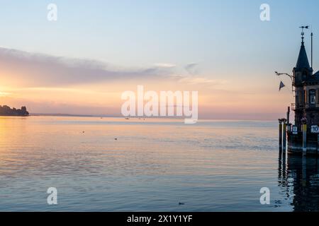 Beschreibung: Schöner Blick auf Sonnenaufgang von der Imperia-Statue zum Leuchtturm am Hafeneingang und am Bodensee in den frühen Morgenstunden. Steamer Harbour, Co Stockfoto