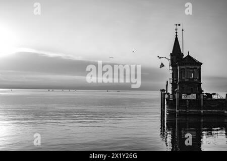 Beschreibung: Schöner Blick auf Sonnenaufgang von der Imperia-Statue zum Leuchtturm am Hafeneingang und am Bodensee in den frühen Morgenstunden. Steamer Harbour, Co Stockfoto