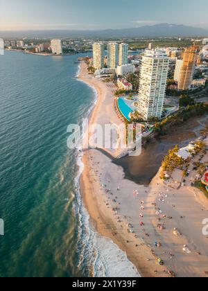 Vertikaler Blick aus der Luft über türkisfarbenes Meereswasser vom Hotel Zone über den Strand mit Blick auf den Yachthafen. Stockfoto