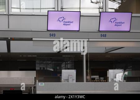 Frankfurt International Airport, Deutschland - 19. Februar 2024: Displays mit Werbung für den Frankfurter Flughafen hängen über der leeren Anzahl der Check-in Stockfoto
