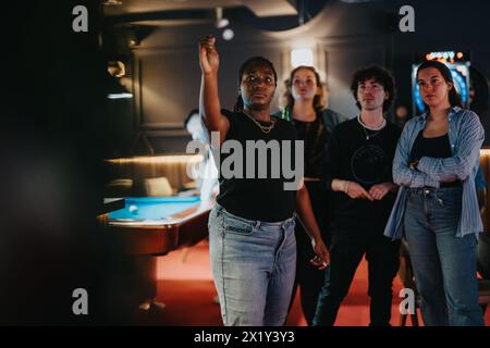 Freunde genießen eine Partie Dart während eines fröhlichen Abends in einer Bar Stockfoto