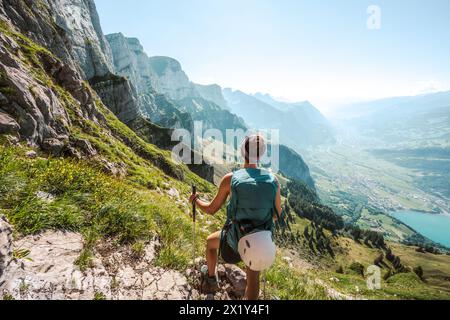 Beschreibung: Sportliche Frau genießt vom Wanderweg unterhalb der steilen Felswände einen Panoramablick auf die Churfürsten. Schnürliweg, Walensee, St. Ga Stockfoto