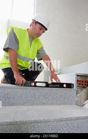 Arbeiter mit Schutzausrüstung, PSA, Nivellierleiter Sprosse, Gehäusebau, Ebene, Baskenland, Spanien. Stockfoto