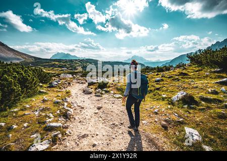 Beschreibung: Junge sportliche Frau spaziert am Nachmittag entlang des malerischen Dolomitenhochwegs. Tre Cime, Dolomiten, Südtirol, Italien, Europa. Stockfoto