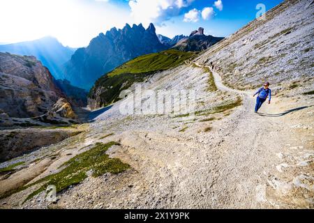Beschreibung: Junge sportliche Frau spaziert am Abend auf dem malerischen Dolomitenhochweg. Tre Cime, Dolomiten, Südtirol, Italien, Europa. Stockfoto