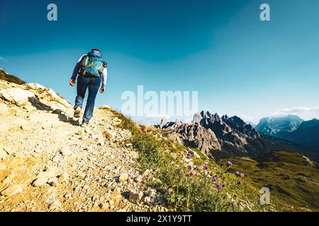 Beschreibung: Junge sportliche Frau spaziert am Abend auf dem malerischen Dolomitenhochweg. Tre Cime, Dolomiten, Südtirol, Italien, Europa. Stockfoto