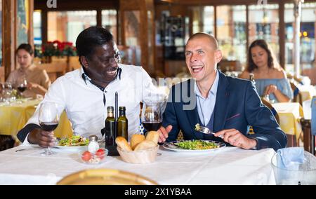 Freunde genießen das Abendessen mit Wein im Restaurant Stockfoto