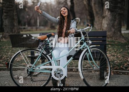 Selbstbewusste Geschäftsfrau, die ein Selfie mit dem Fahrrad im Stadtpark macht Stockfoto