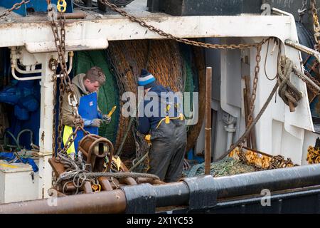 18. April 2024. Fraserburgh Harbour, Aberdeenshire, Schottland. Hier sind 2 Fischer an Bord eines Fischerbootes, die im Hafen von Fraserburgh anlegen und die F reparieren Stockfoto