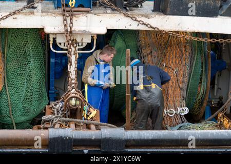 18. April 2024. Fraserburgh Harbour, Aberdeenshire, Schottland. Hier sind 2 Fischer an Bord eines Fischerbootes, die im Hafen von Fraserburgh anlegen und die F reparieren Stockfoto