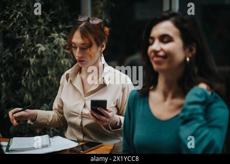 Startup-Kollegen in einem Café, die ein Brainstorming über einen neuen Geschäftsplan erarbeiten Stockfoto