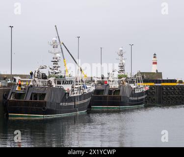 18. April 2024. Fraserburgh Harbour, Aberdeenshire, Schottland. Das sind zwei Fraserburgh registrierte Fischerboote, die in ihrem Hafen auf einem grauen Clo liegen Stockfoto