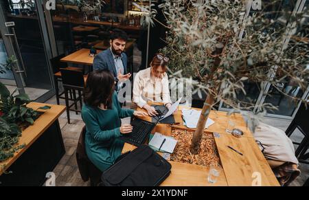 Das unternehmerische Team diskutiert Strategien in einem städtischen Café Stockfoto
