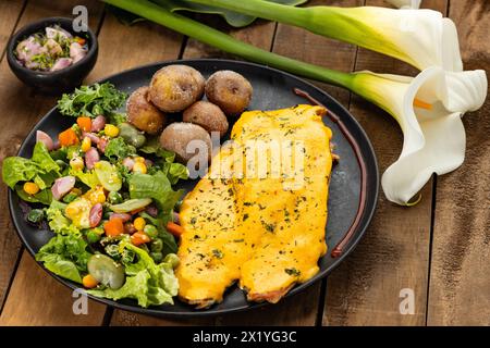 Gebratene Forelle in Zwiebelsauce mit Salat und gebackenen Kartoffeln gebadet Stockfoto