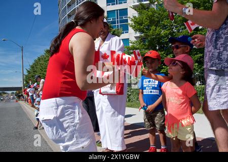 Toronto, Ontario / Kanada - 1. Juli 2019: Kinder erhalten die Nationalflaggen bei der Canada Day Parade Stockfoto