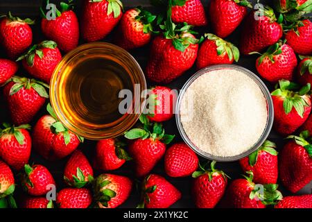 Erdbeere Bourbon konservierte Zutaten: Frische Erdbeeren umgeben Gerichte aus Bourbon-Whiskey und Bio-Rohrzucker, von oben gesehen Stockfoto