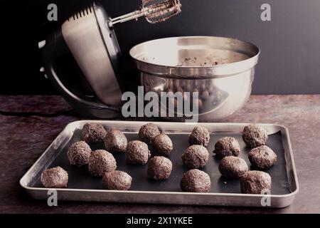 Uncoated Cookies and Cream Truffles on a Sheet Pan: Füllungen mit Schokoladenrahm-Trüffeln mit Handrührgerät und Rührschüssel im Hintergrund Stockfoto