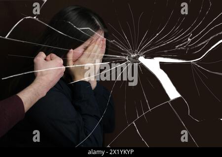 Die Faust eines Mannes vor einer weinenden Frau, Nahaufnahme auf dunklem Hintergrund, Vorstellung von Stress, psychologischer Gewalt, häuslichem Missbrauch Stockfoto