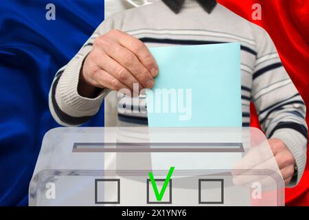 Männliche Wähler lassen einen Wahlzettel in einer transparenten Wahlbox vor dem Hintergrund der Nationalflagge Frankreichs, Konzept der Staatswahlen, Referendum fallen Stockfoto