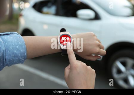 Frau mit SOS-Funktion bei Smartwatch im Freien, Nahaufnahme Stockfoto