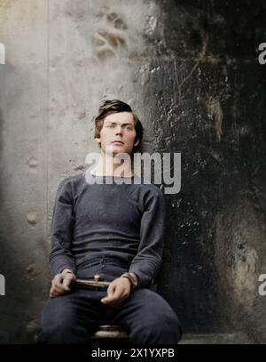 Lewis Powell (auch bekannt als Lewis Payne), in Pullover, sitzend und mit Manakeln, einer der Verschwörer beim Attentat auf Abraham Lincoln. Dieses Foto hat einen Hintergrund aus dunklem Metall und wurde vermutlich auf U.S.S. Saugus aufgenommen, wo er eine Zeitlang eingesperrt war. Washington Navy Yard, District of Columbia. 27. April 1865. Von Alexander Gardner. Stockfoto