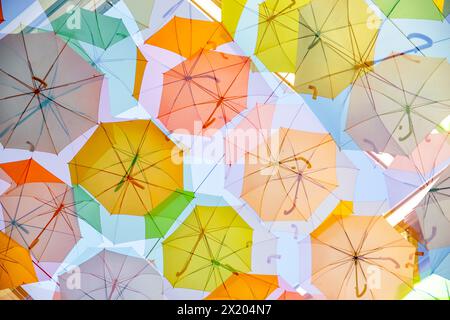 Mehrfache Exposition von bunten Regenschirmen, die über einer Straße hängen, um Schatten in Bordeaux, Frankreich, zu spenden. Stockfoto