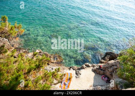 Dubrovnik Kroatien - 29. Mai 2011; Strandtuch und Buch liegen auf einem kleinen Felsvorsprung am Rand des Mittelmeerkroatiens Stockfoto