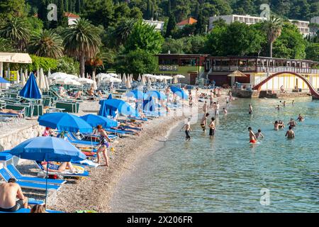 Dubrovnik Kroatien - 29. Mai 2011; redaktioneller überfüllter Uvala Lapad Strand mit Menschen und blauem Schirm. Stockfoto