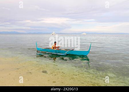 Ein philippinischer Fischer in einem bangka-Boot in Malapascua, Central Visayas, den Philippinen. Stockfoto